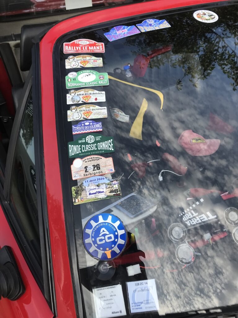 Une FERRARI qui a des "heures de vol", d'après les nombreux autocollants posés sur le pare-brise, témoignant de chaque épreuve disputée avec cette auto